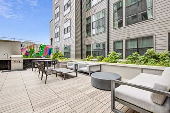 A communal patio with seating and tables in front of a building